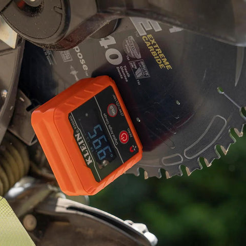 Klein Tools 935DAG orange digital angle gauge mounted on a circular saw, displaying angle measurement.