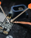 Close-up of Six Piece Soldering Assist Set Desoldering Pump And Wick Kit for PCBs One Handed Solder Aid Tools in use