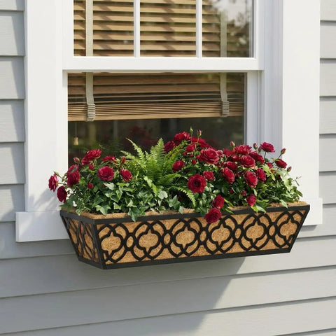 Adjustable Deck Railing Planter Boxes For Balcony Gardens Fits Railings From 2.1 To 6.3 Inches With Sturdy Metal Construction Ideal For Outdoor Plants On Deck Fence Or Porch Window Boxes Outdoor 24 Inch Long 4 Pack With Coco Coir Liner installed below a window holding red flowers and greenery.