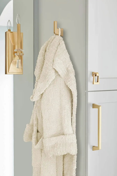 Blackrock Champagne Bronze Cabinet Pull With 6 5/16 Inch Hole Spacing And Smooth Transitional Vibe That Gives Kitchen Drawers Bathroom Vanities Or Any Furniture Piece A Sick Home Glow Up Right Now, featuring a bathrobe on a hook.