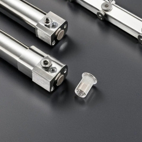 Stainless Steel Pro Grade Rivet Nut Kit 70 Pack Flat Head Threaded Inserts next to precision instruments on gray surface