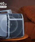 4 in 1 Portable Air Conditioner for Home or Office with Cooling and Heating, Dehumidifier, Quiet Fan, Remote Control and Touch Panel, Compact Swamp Cooler for All Season Comfort on a coffee table.