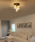 Three-Light Semi Flush Mount Ceiling Light Fixture With Dope Clear Glass Cylinder Shades In Gold Finish in living room