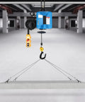 Heavy Duty Electric Hoist With 1100 Lb Capacity And 1500W Motor hanging concrete slab, featuring a blue body and yellow remote.