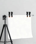 Five Pack Four And A Half Inch Spring Clamps For Backdrops And Crafts securing white backdrop on stand