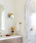 Gold Globe Wall Sconces Set of Two, Dope Brass Modern Vanity Lights With Milky White Glass Shades in bathroom setting