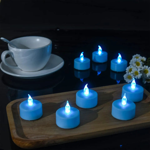 Blue LED Tea Lights 24 Pack Battery Operated Flameless Votive Candles With Realistic Flicker And Long Lasting Up To 200 Hours displayed on a table with a teacup and flowers