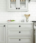 Matte Black Zinc Cabinet Knob And Drawer Pull Set installed in a modern kitchen, showcasing smooth finish and Euro style.