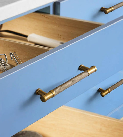 Close-up of Six Pack Knurled Cabinet Pulls Antique Brass Drawer Handles 5.04 Inch on blue kitchen drawers.