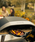 Koda 16 Inch Propane Gas Pizza Oven with 28 MBAR Regulator and Hose Outdoor Portable Oven in use, baking pizza outdoors.