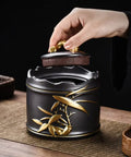 Hand lifting the lid of a Heavy Duty Ceramic Coffee Canister With Locking Airtight Lid on a wooden table.