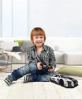 Child playing with Audi R8 LMS Style Remote Control Car 1 14 Scale High Speed RC Toy For Adults Kids Full Function Forward Reverse Left Right On Flat Surfaces Officially Licensed By Audi AG