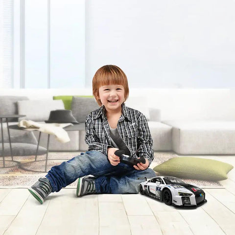 Child playing with Audi R8 LMS Style Remote Control Car 1 14 Scale High Speed RC Toy For Adults Kids Full Function Forward Reverse Left Right On Flat Surfaces Officially Licensed By Audi AG