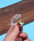 Hand holding Two Pack Premium Crystal Glass Cabinet Handles Slick Luxury Modern Pulls for Cabinets and Drawers Golden Finish 20mm Diameter