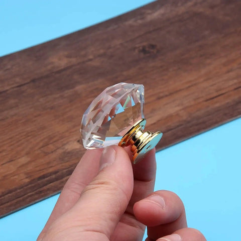 Hand holding Two Pack Premium Crystal Glass Cabinet Handles Slick Luxury Modern Pulls for Cabinets and Drawers Golden Finish 20mm Diameter