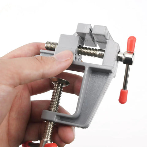 Hand holding Mini Jeweler Table Clamp For Jewelry Making And Electronics Craft Projects Portable Bench Vise in gray aluminum