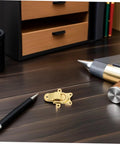 Chic 2pcs Retro Golden Duckbill Toggle Latches Fit Any Wooden Chest Or Toolbox With Stunning Zinc Alloy Finish For Vintage Decor And Secure Fastening. Gold zinc alloy latch on desk with wooden drawer and pens