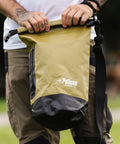 Person holding ExoDry 20L Dry Bag With Roll Top Closure, Waterproof Gear Carrier for kayaking and fishing, black with shoulder strap