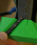 No Fuss Manual Drill Bit Sharpening Guide Jig aligns 118 degree twist bit for sharpening on a bench grinder.
