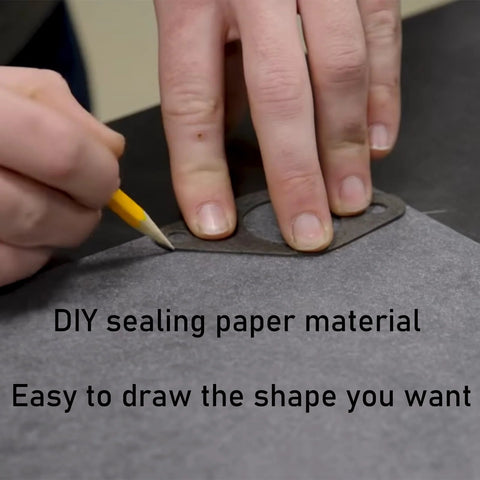 Close-up of a hand tracing a gasket outline on HTJZWG non-asbestos gasket sheet (dark gray)