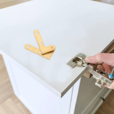 Hand installing Concealed Pivot Door Hinges 4 Pack Heavy Duty Brass Hidden Shaft Hardware For Metal Doors And Windows on cabinet