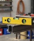 Spirit Level, Aluminum Alloy, 250mm positioned on steel beams, showcasing its bubble levels for precise alignment.