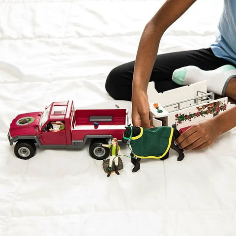 Child playing with 38 Piece Trailer And Truck Transporter Playset With Realistic Horse And Rider Figures Saddle Bridle Hay Bales And Accessories