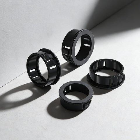 Close-up of 305 Piece Black Nylon Cable Snap Grommets Set Round Locking Bushing Protectors For Wires on gray background