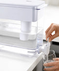 9L Water Dispenser System For Home Or Office, 40 Cup Countertop Hydration Station pouring water into a glass