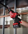 M18 Fuel One Handed Reciprocating Saw Kit cutting copper pipe, detailed view of grip and battery for home renovation projects.