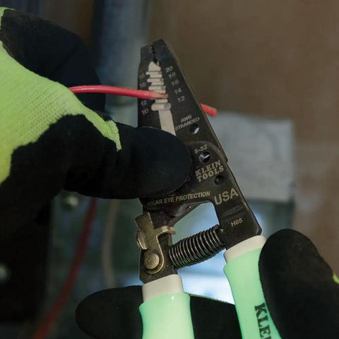 Glow In The Dark Grips Wire Stripper And Cutter With Serrated Curve Nose For 10 To 18 AWG Solid And 12 To 20 AWG Stranded Wire Pro Grade Tool Made In USA being used to strip red wire