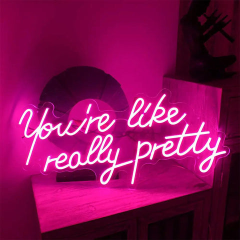 You Are Really Pretty Pink Led Neon Sign For Indoor Bedroom Decor Wall Art Backdrop 25.5x11.8 Inches Flexible Silicone Neon Light For Chill Vibe Parties Weddings Living Room, lit in a romantic glow on a shelf against a dark background.