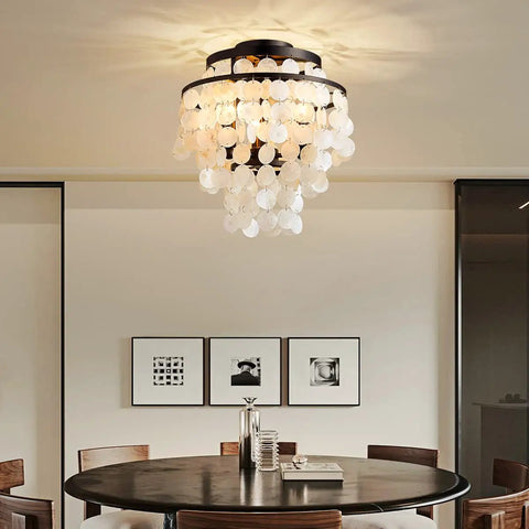 Capiz Shell Semi Flush Mount Ceiling Light in Matte Black for Bedroom and Kitchen Dope Coastal Style Pendant Fixture With Hundreds of Capiz Shells Elegant Romantic Ocean Vibe for Hallway and Entry, viewed in a dining room setting.