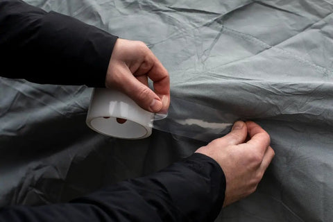 Hands apply Crystal Clear All Weather Repair Tape For Indoor And Outdoor Use, UV Resistant And Weatherproof, 1.88 Inch Wide