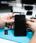 DIY Glass Repair Liquid Quick Fix for Cracks and Scratches, 5ml bottle next to a smartphone with visible screen cracks.