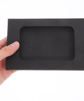 Hand holding Black Window Envelopes Set 30 Pack Small Size For Business Cards Photos And Invitations with clear window and flap seal.