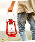 Person holding red kerosene lantern for outdoor use, suitable with 10 Piece Cotton Wick Set For Oil Lamps Kerosene And Propane Lanterns Gas
