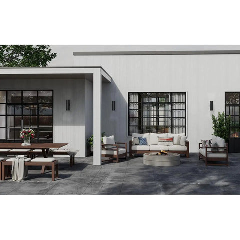 Modern outdoor seating area with 6-Inch Outdoor LED Cylinder Wall Sconce 2-Light Up And Down Mount, black, on white walls