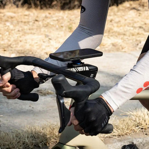Cyclist adjusting Bike Handlebar And Stem Phone Mount Kit With MAG Universal Adapter And Dual Lock during outdoor ride