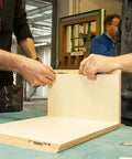 Two carpenters assembling wood panels using Heavy Duty Aluminum Biscuit Connectors Size 20 Slide In Joint Locators for Cabinet Shop.