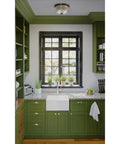 Kitchen with green cabinets and vintage brass two light close to ceiling flush mount fixture in Archie Collection style