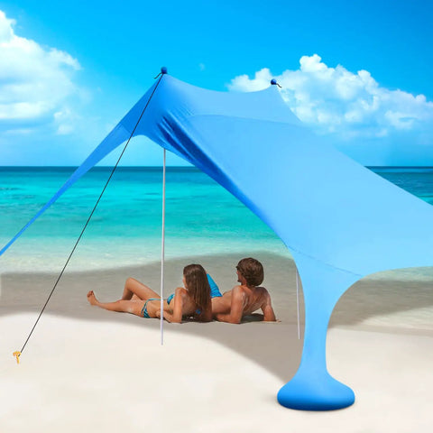 Couple under Ultra Portable Beach Tent Canopy With UPF50 Sun Protection on a sunny beach, showing its spacious design and strong poles.