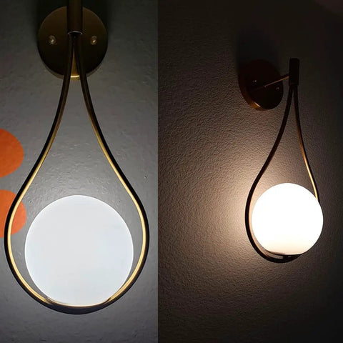 Lit Mid Century Modern Wall Sconces Set Of 2 With Globe Glass Shades In Antique Brass Finish, mounted on a wall, soft lighting.