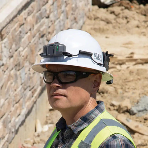 Worker wearing hard hat with Power Packed 3200 mAh USB C Portable Battery for cooling fans, safety gear on construction site