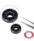 Close-up of Silicon Nitride 608-2RS Ceramic Bearings Pre Lubricated For Skates And Scooters ABEC 7 with tweezers and spacer