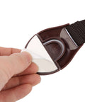 Hand holding Baby Safety Locks For Cabinets And Drawers Adhesive Child Proofing Locks with brown ABS part and nylon belt.