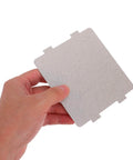 Hand holding a grey sheet from 10 Pack Microwave Oven Mica Sheets Heat Insulation Cover Cuttable Design For Easy Replacement And No Fuss Installation.