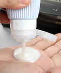 Person dispensing liquid from TSA Approved Travel Bottle Set With Leak Proof Silicone Squeezable Containers for Toiletries.