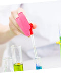 Person using pink Nitrile Latex Finger Cots while handling a dropper over test tubes, promoting safe worksite use.