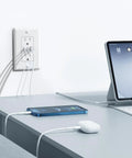 Haul This Smooth Usb Wall Outlet With Two Type C And One Type A Ports For Reliable Six Amp Fast Charging To Keep Every Gadget Pumped Full Of Juice No Fuss Ever Just Install And Go In Classic White near a desk with cables connected to a phone and tablet.